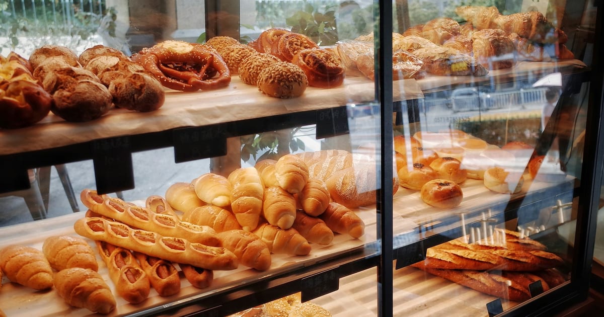 A bakery display cabinet filled with breads, croissants and pastries.