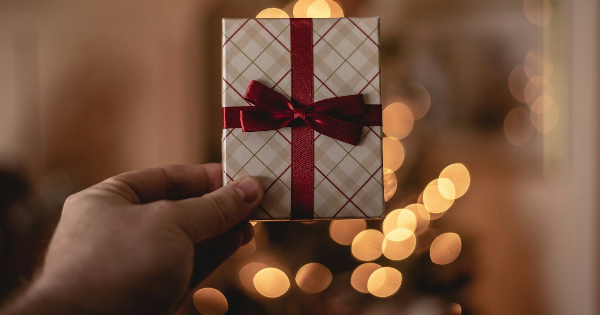 A hand holding a plain white gift card.