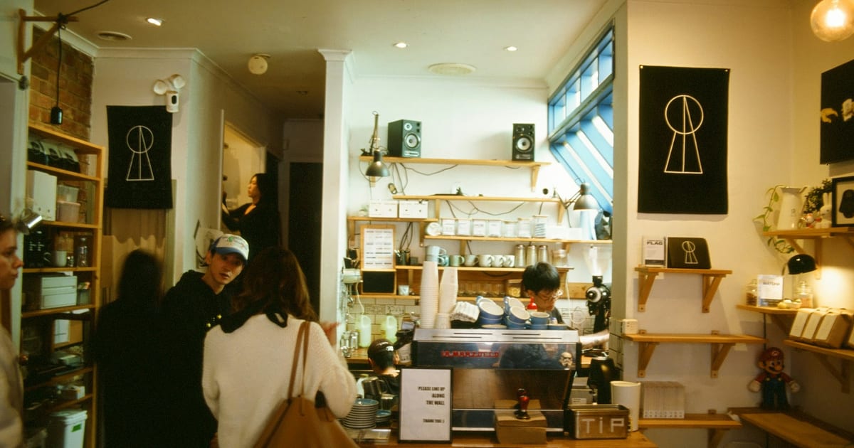 Customers waiting to order at a coffee shop counter.