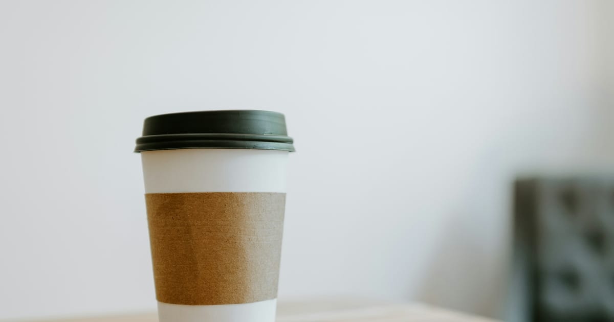 A takeaway coffee cup standing on a counter.