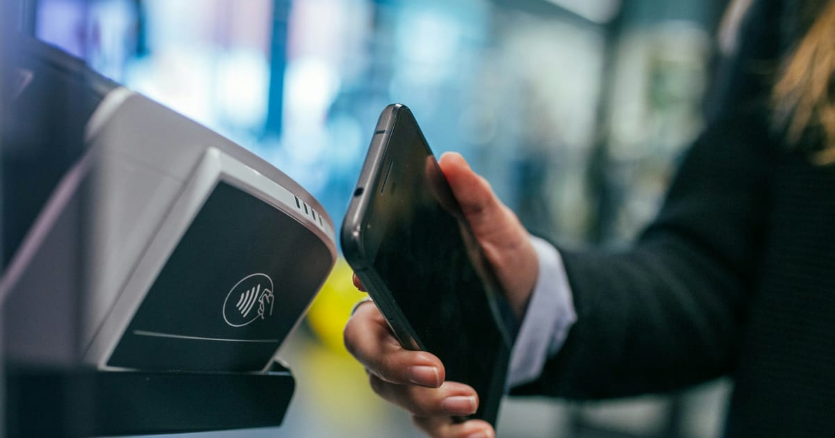 A woman holding a smartphone in one hand.