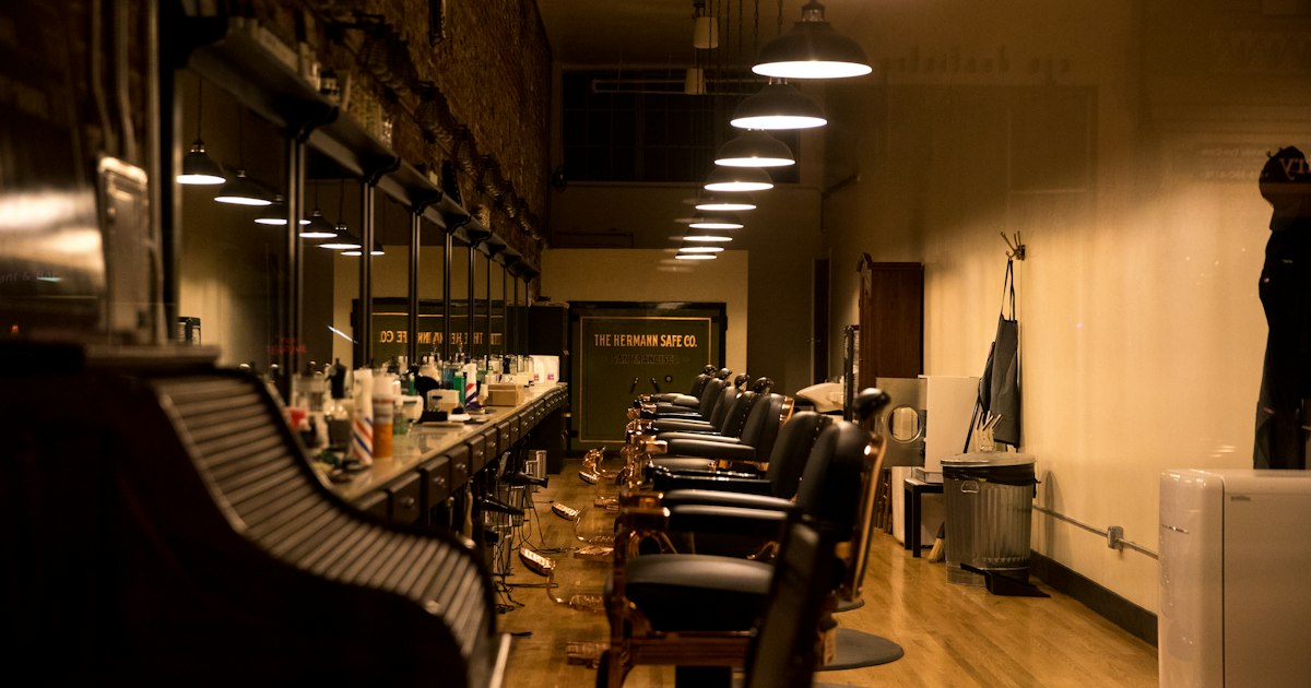 A row of empty barber's chairs in an unoccupied shop.