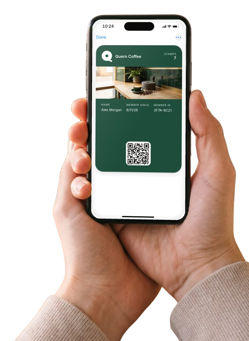 A hand holding a phone open to Apple Wallet, on the loyalty card of Quern Coffee, an example shop, with 7 stamps.