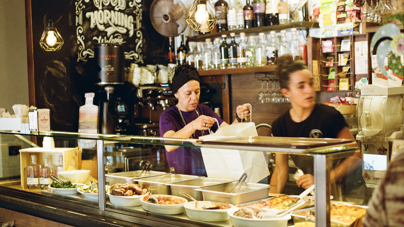 Staff serving from behind a hot food counter.